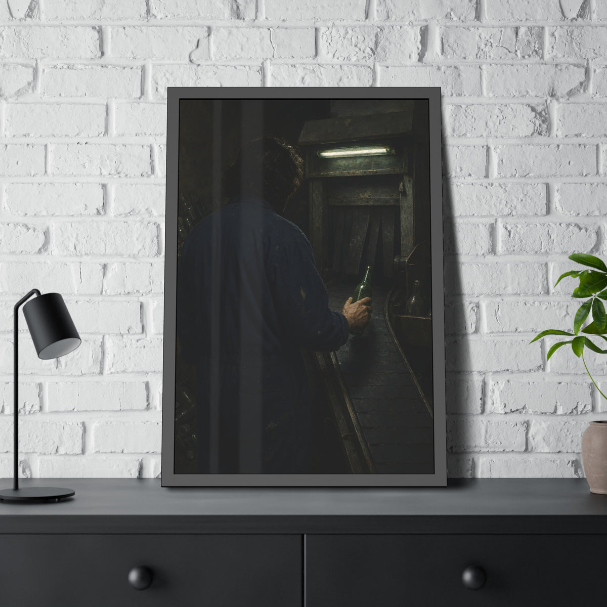 A man in coveralls sets a green bottle on a conveyor under a strip light. Garabaggio at the Conveyor by Garabaggio, framed fine art print hanging in a room.