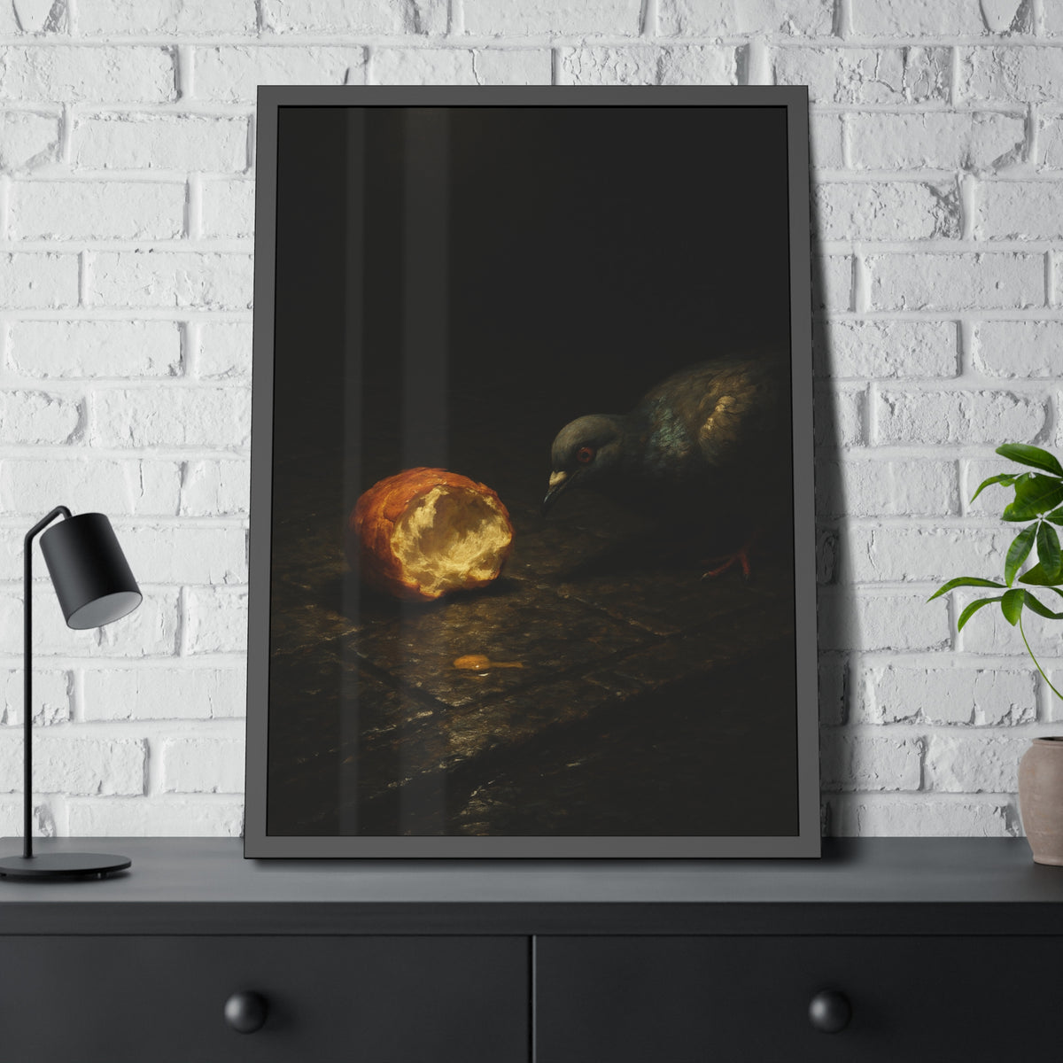 A pigeon leaning toward a torn bread roll on wet paving stones. The Offering of the Discarded Bun by Garabaggio, framed fine art print hanging in a room.