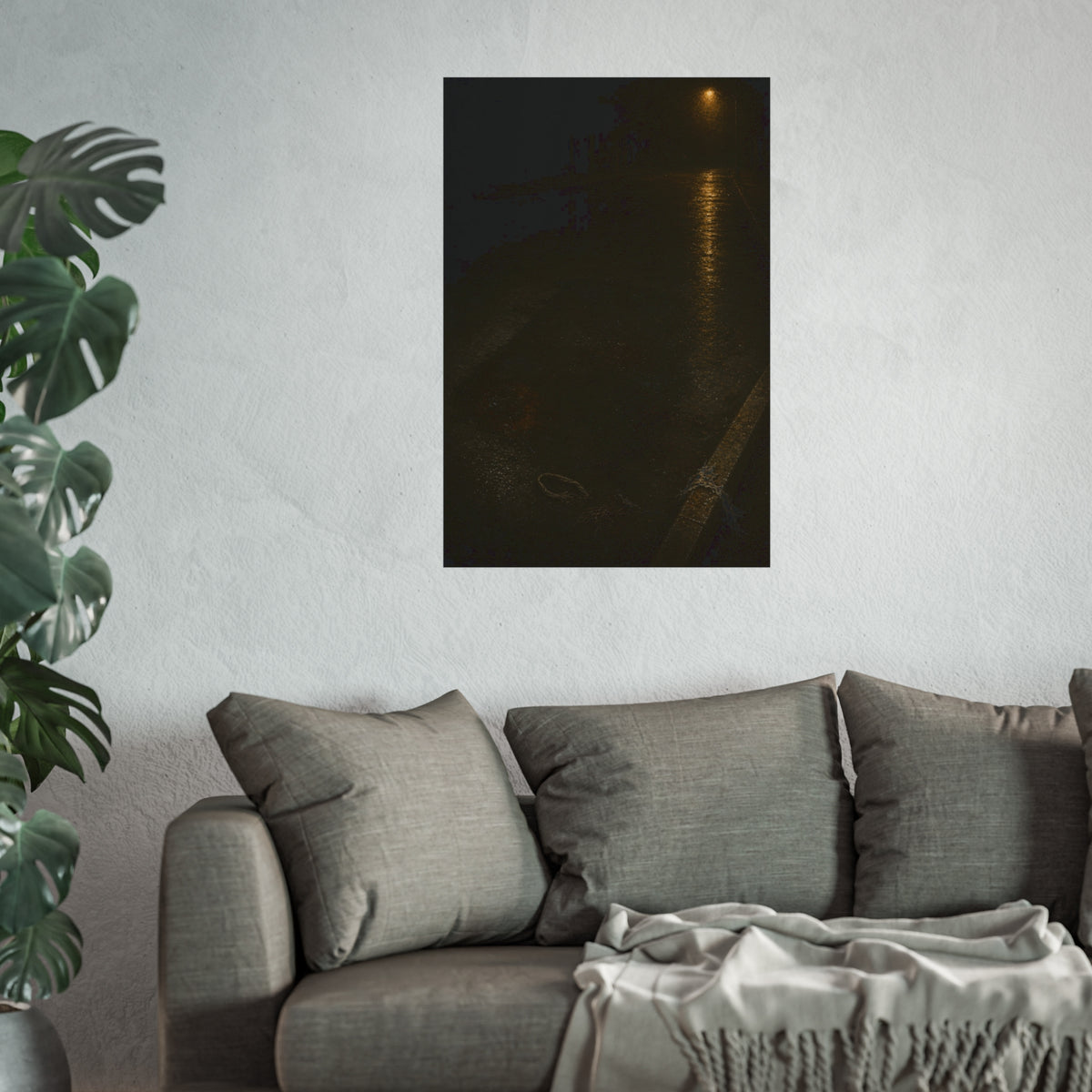 A rectangular stain on wet asphalt where something lay, under a streetlamp. The Stain After Removal by Garabaggio, fine art print hanging in a room.