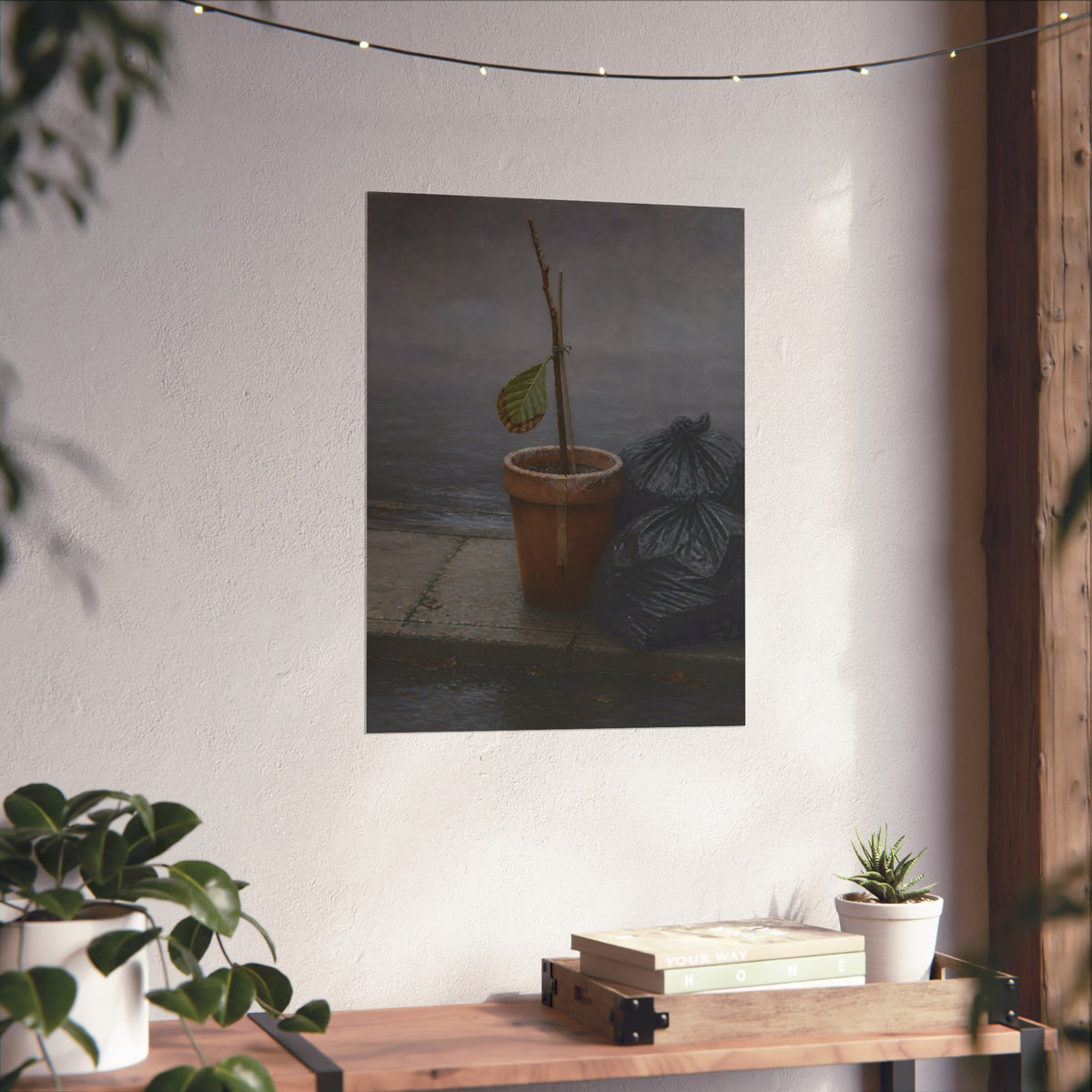 A potted dead twig with one leaf beside black garbage bags on a wet curb. The Curb on Tuesday by Garabaggio, fine art print hanging in a room.