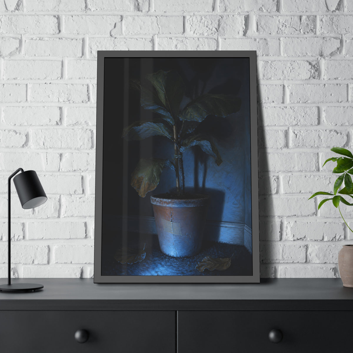 A dying potted plant in a corner washed in blue television light. The Television Hours by Garabaggio, framed fine art print hanging in a room.