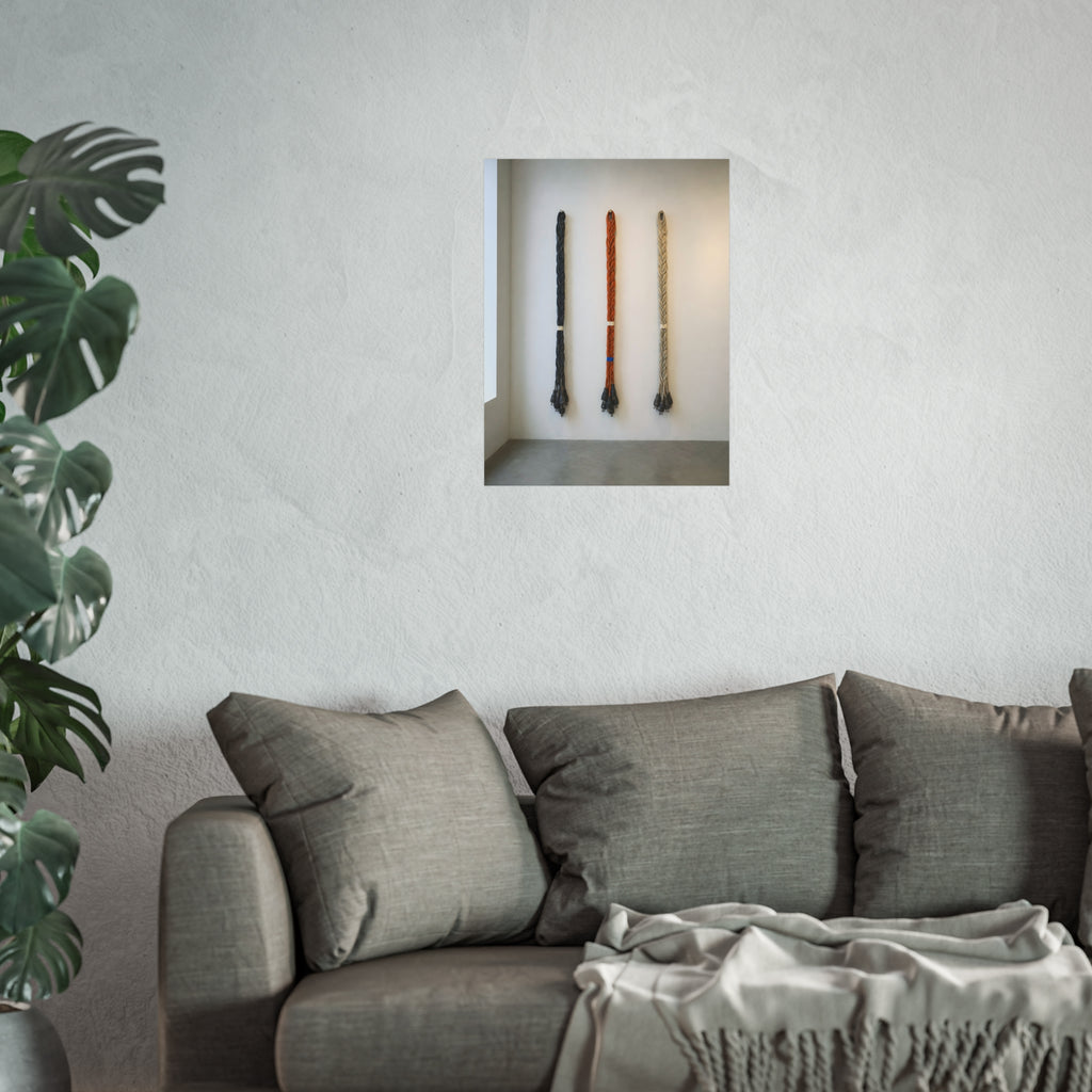 Three braided bundles of extension cords hung on a white gallery wall. The Braided Triptych by Garabaggio, fine art print hanging in a room.