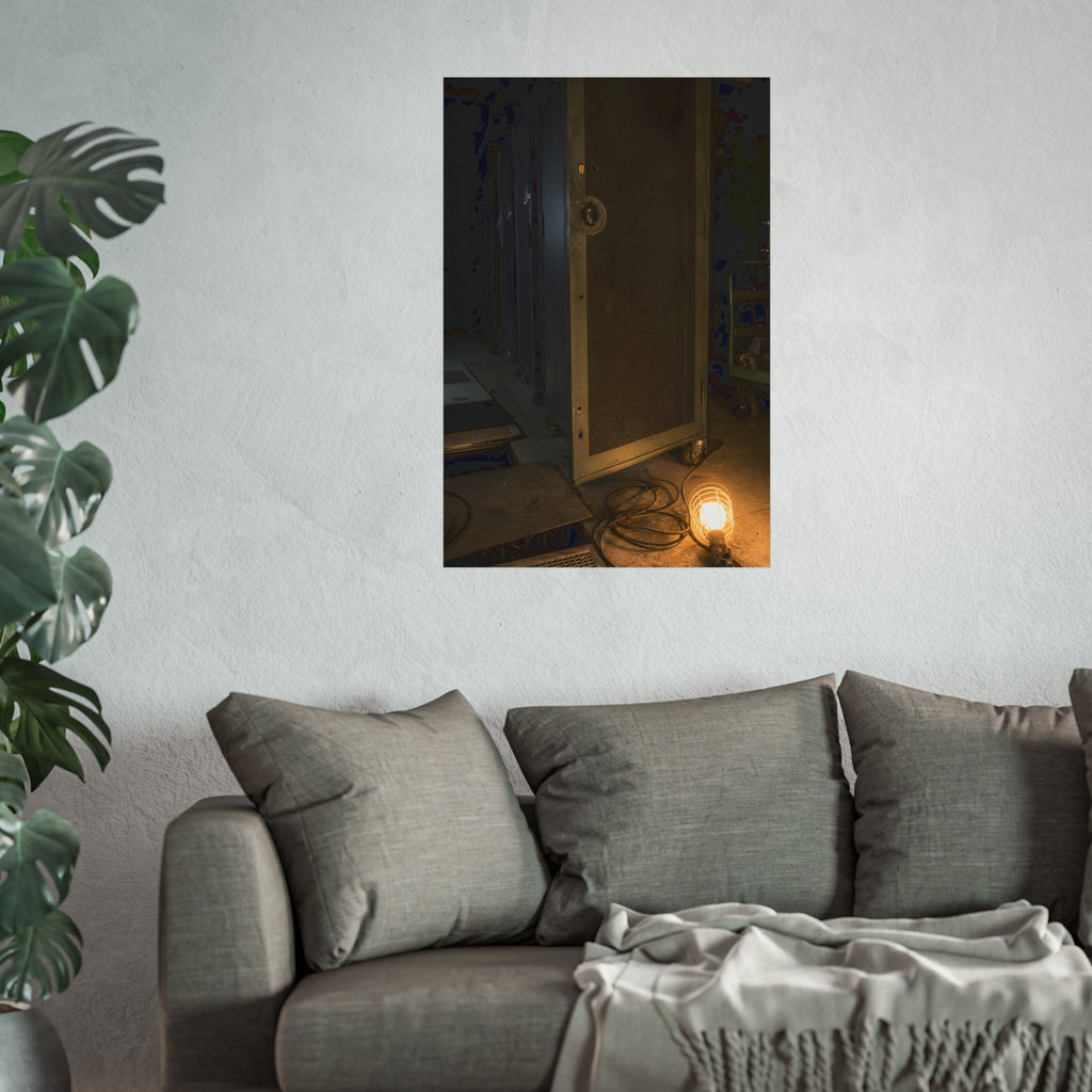 A perforated server rack door in a dark aisle lit by a floor work lamp. The Cold Aisle by Garabaggio, fine art print hanging in a room.
