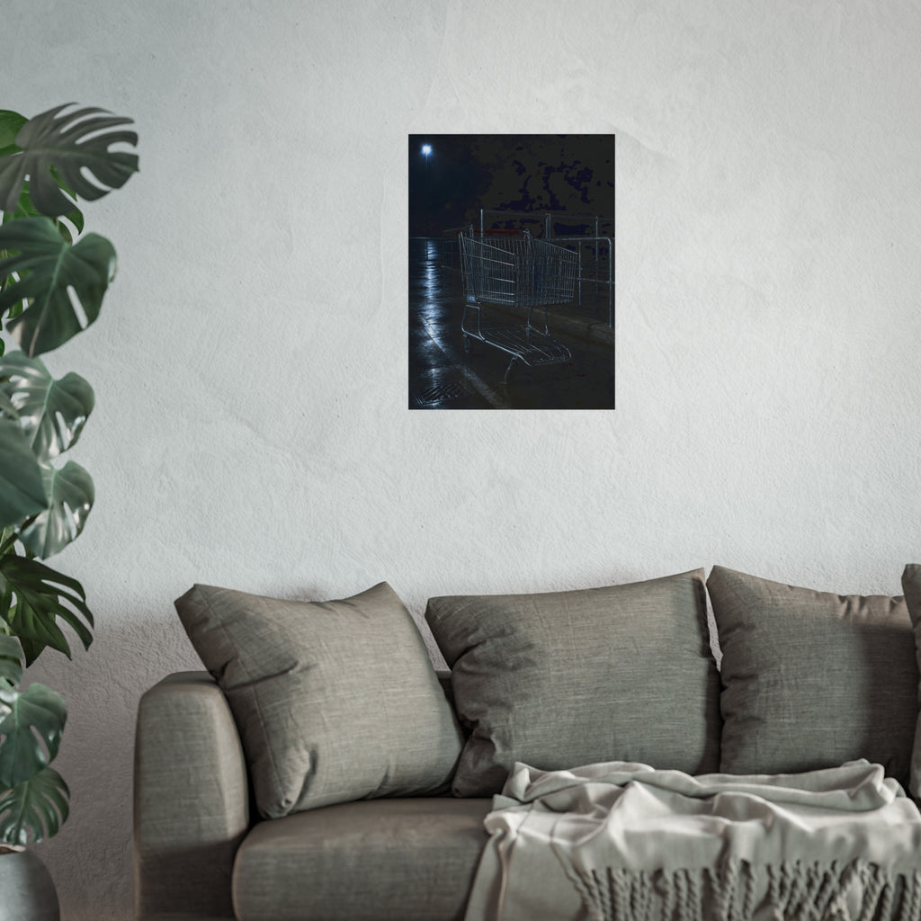 A shopping cart beside its corral on wet asphalt under a lot light. The Cart at the Corral by Garabaggio, fine art print hanging in a room.