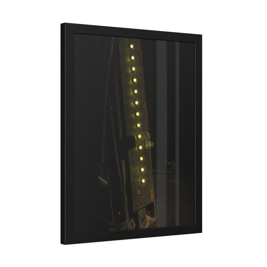 A dark rack panel with a vertical row of glowing green indicator lights. The First Green Choir by Garabaggio, framed fine art print hanging in a room.