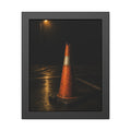 A battered orange traffic cone on wet asphalt under a street lamp. The Warning Without Danger by Garabaggio, framed fine art print, 11″ x 14″.