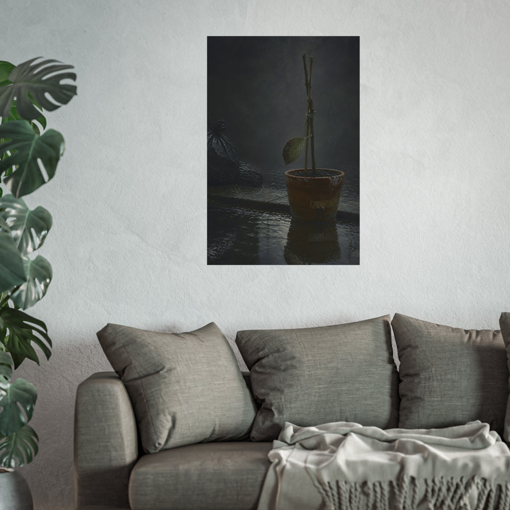 Bare tied stems in a clay pot on flooded pavement, one leaf remaining. The Grey Between by Garabaggio, fine art print hanging in a room.