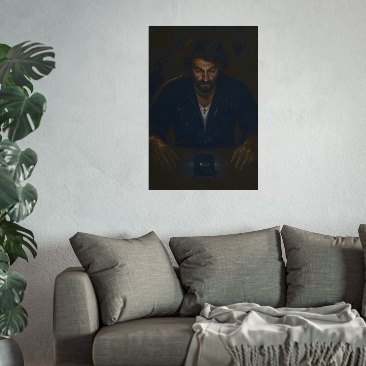 A man in a work jacket looks down at a phone showing a red low battery icon. The Calling at One Percent by Garabaggio, fine art print hanging in a room.