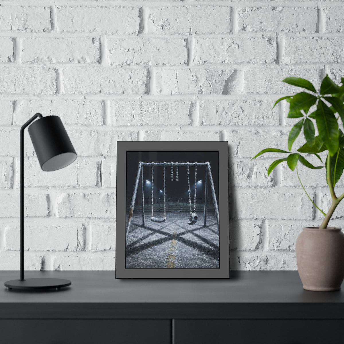 A frost covered swing set on empty asphalt under distant floodlights. The Third Hour: The Coldest Part by Garabaggio, framed fine art print hanging in a room.