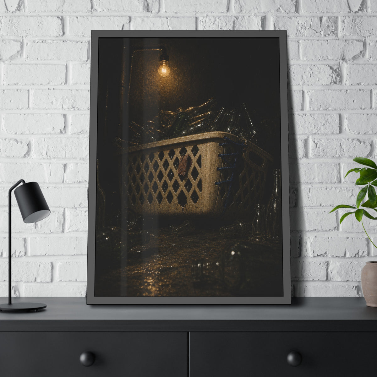 A laundry basket filled with glass bottles under a bare hanging bulb. The Second Life for Bottles by Garabaggio, framed fine art print hanging in a room.
