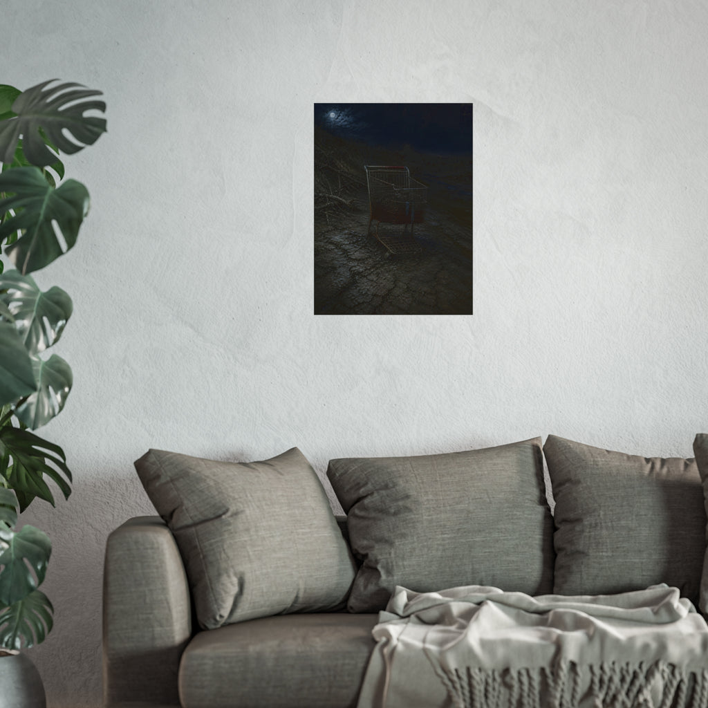 A rusted shopping cart sunk in cracked dried mud under a full moon. The Silting by Garabaggio, fine art print hanging in a room.