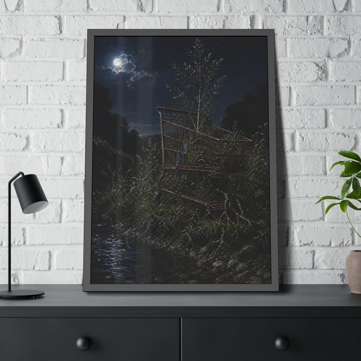 A shopping cart in creekside weeds with a sapling growing up through it. The Cart Grown Through by Garabaggio, framed fine art print hanging in a room.