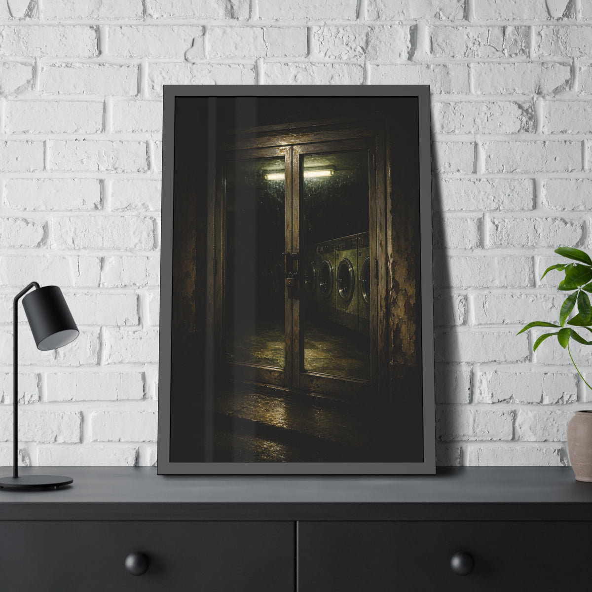 Glass laundromat doors at night with washers lit by a fluorescent tube. The Doors at Midnight by Garabaggio, framed fine art print hanging in a room.