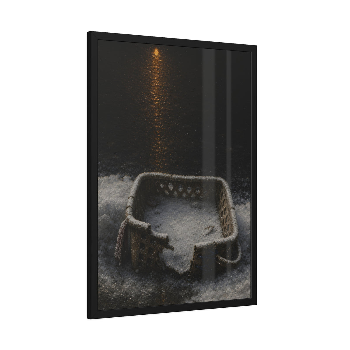 A cracked laundry basket half buried in snow under a distant lamp. The First Snow by Garabaggio, framed fine art print hanging in a room.
