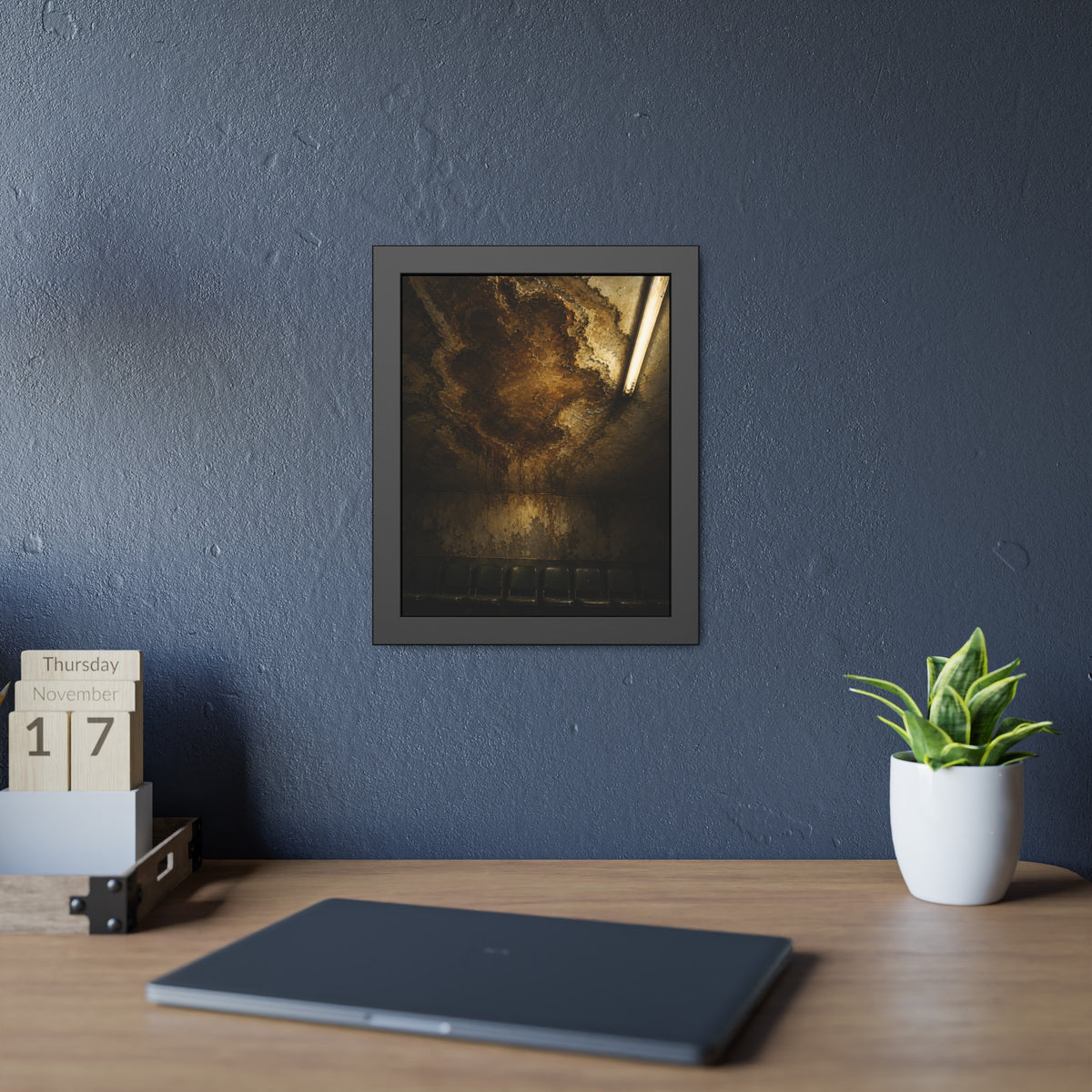 A brown water stain spreading across a ceiling above a row of chairs. The Stain Above the Row by Garabaggio, framed fine art print hanging in a room.