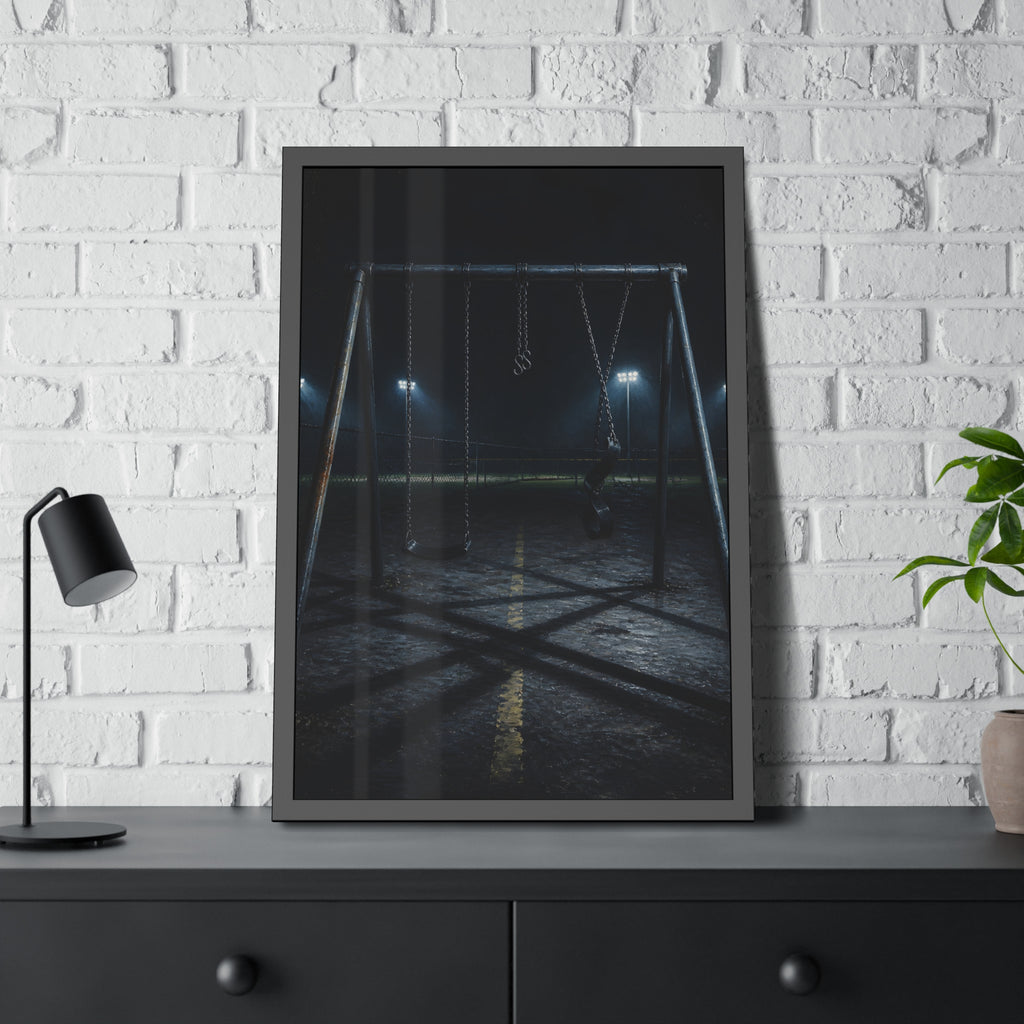 An empty swing set at night with field lights glowing behind it. The Ninth Hour: The Seat Still Moving by Garabaggio, framed fine art print hanging in a room.