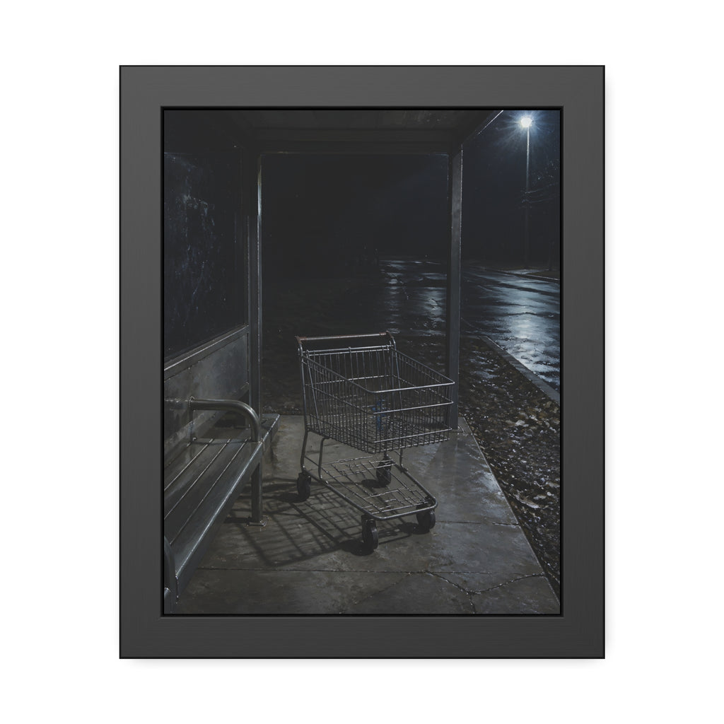 A shopping cart parked inside a bus shelter under a street lamp at night. The Rest at the Bus Shelter by Garabaggio, framed fine art print, 11″ x 14″.