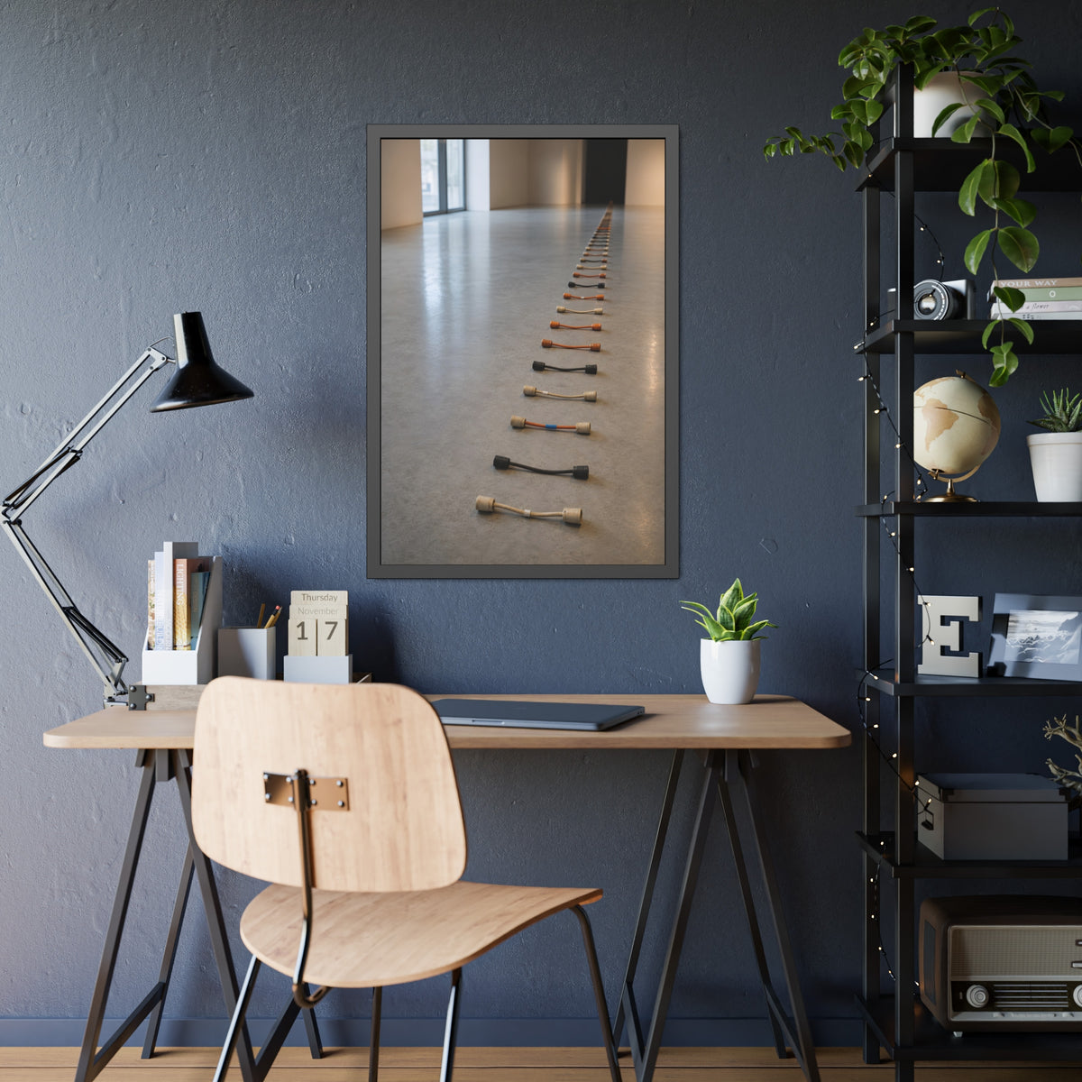 A long line of cut extension cord ends laid across a pale gallery floor. The Severed Procession by Garabaggio, framed fine art print hanging in a room.