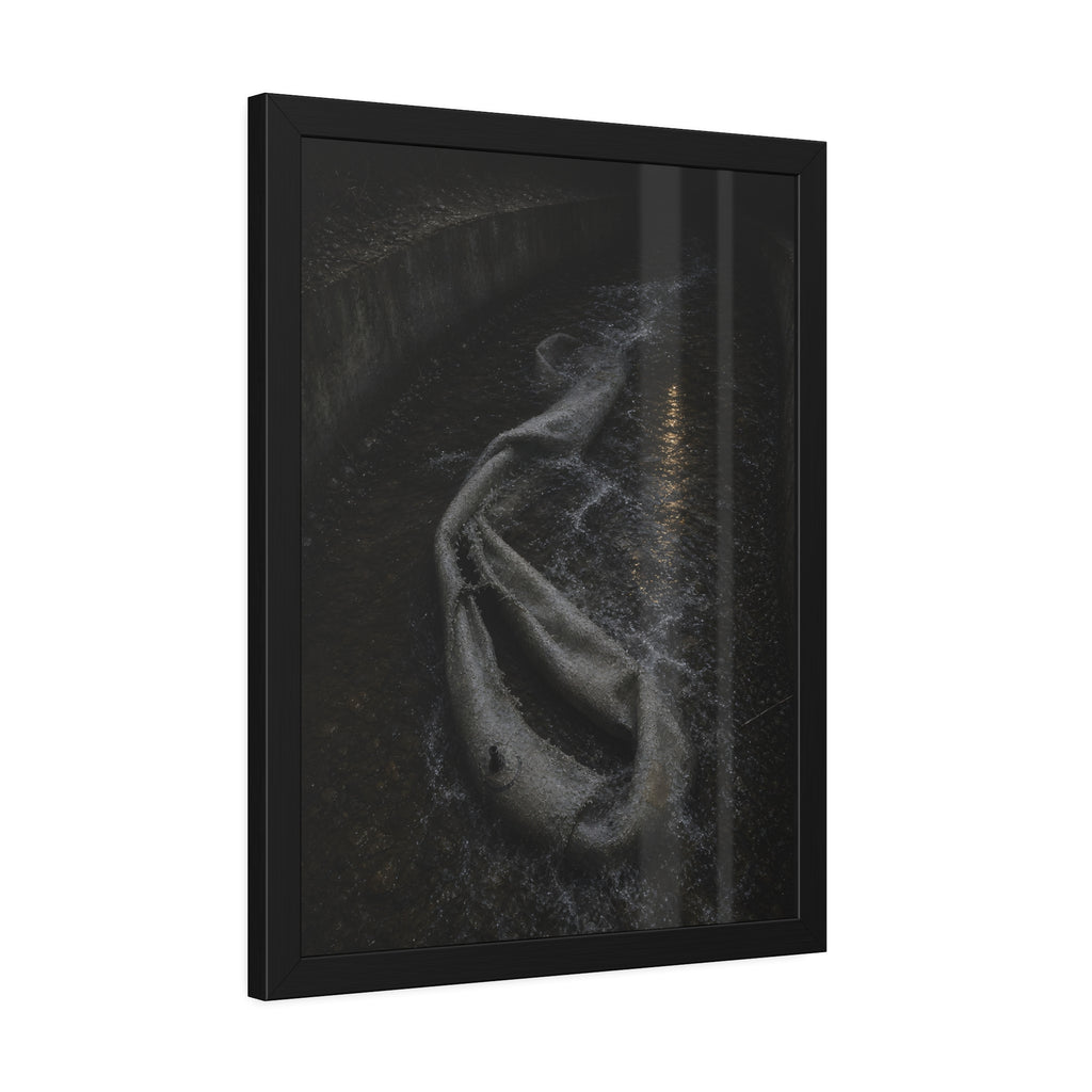 A deflated pool float caught in a concrete drainage channel of running water. The Release into Runoff by Garabaggio, framed fine art print hanging in a room.