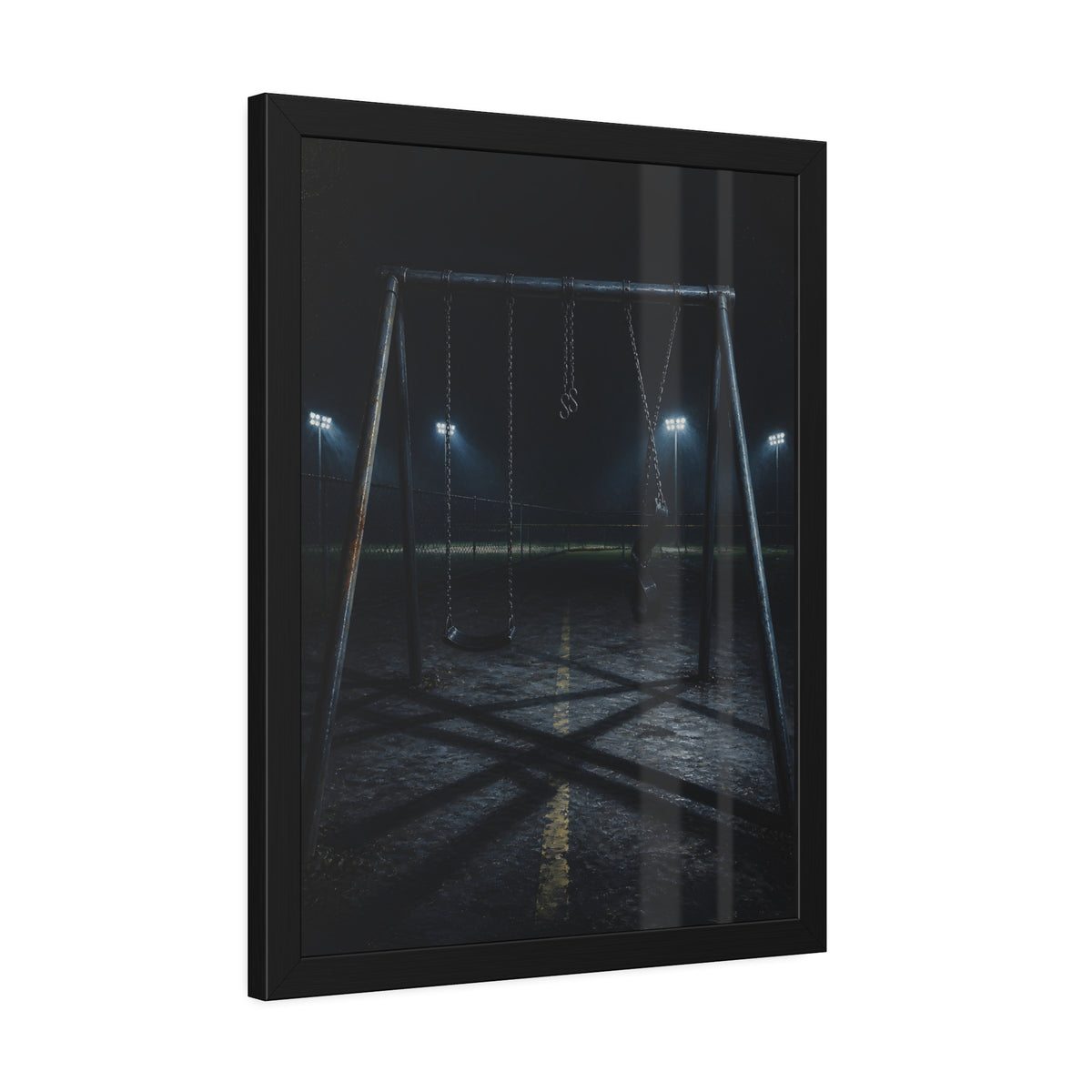 An empty swing set at night with field lights glowing behind it. The Ninth Hour: The Seat Still Moving by Garabaggio, framed fine art print hanging in a room.