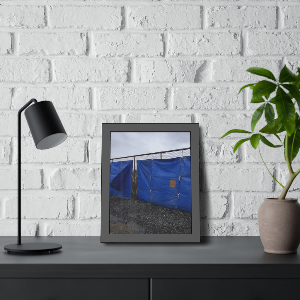 Blue tarps lashed to a chain link fence above gravel under grey sky. Drapery on the Fence by Garabaggio, framed fine art print hanging in a room.