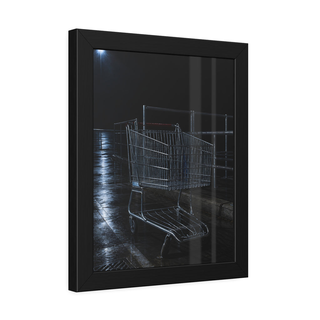 A shopping cart beside its corral on wet asphalt under a lot light. The Cart at the Corral by Garabaggio, framed fine art print hanging in a room.