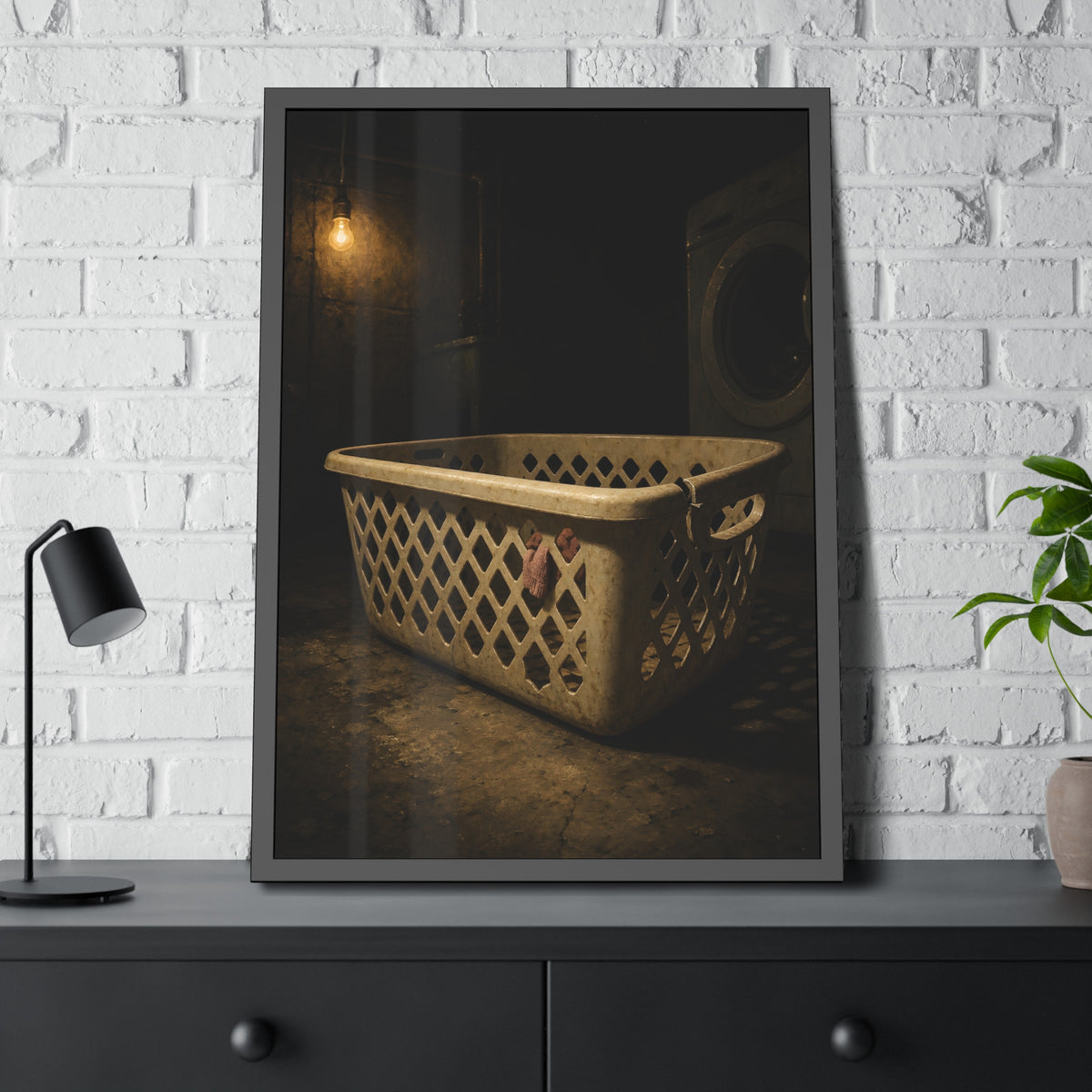 A plastic laundry basket on a basement floor under a bare hanging bulb. The First Split by Garabaggio, framed fine art print hanging in a room.