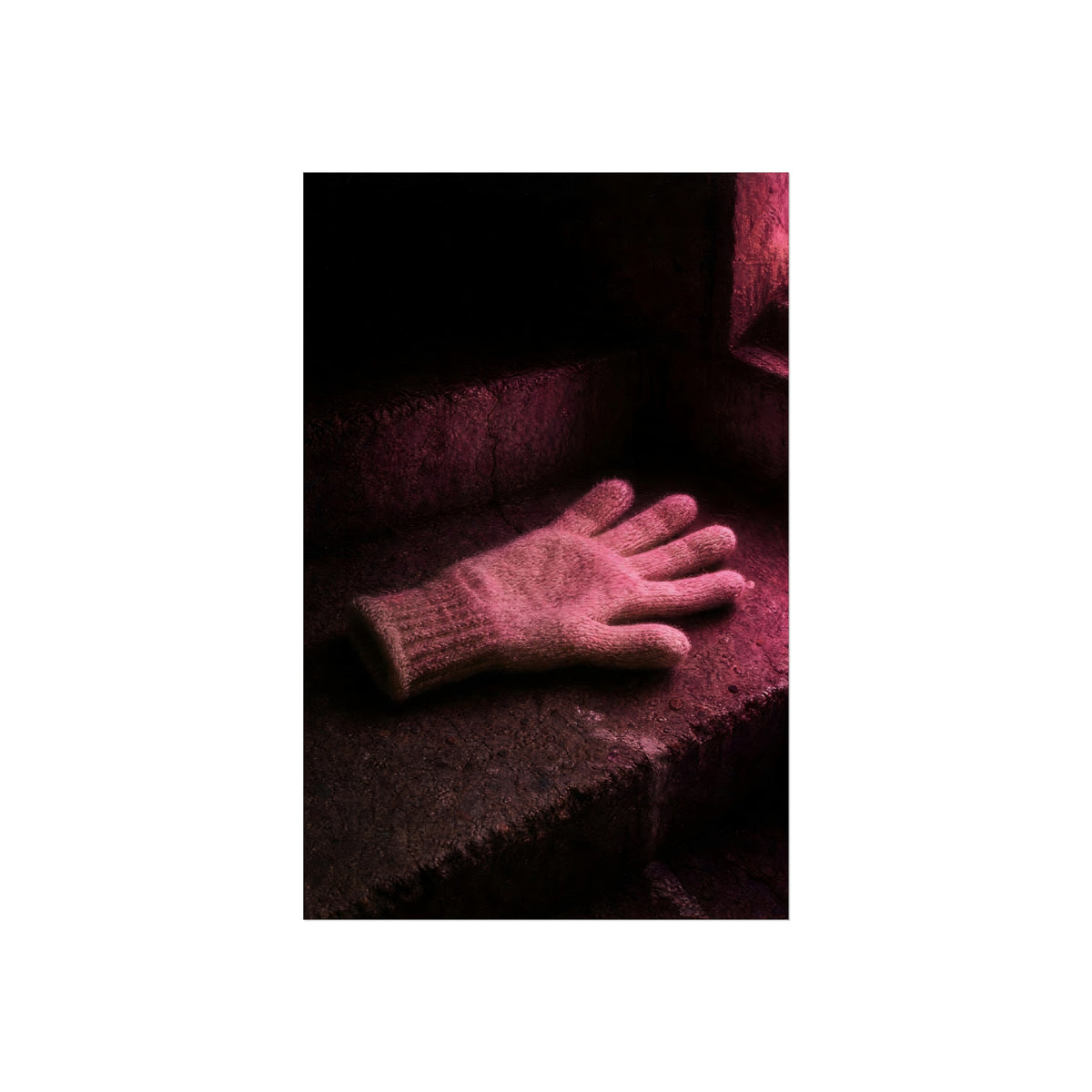A knitted glove lying flat on a concrete step under pink light. The Vigil in Pink Light by Garabaggio, fine art print hanging in a room.