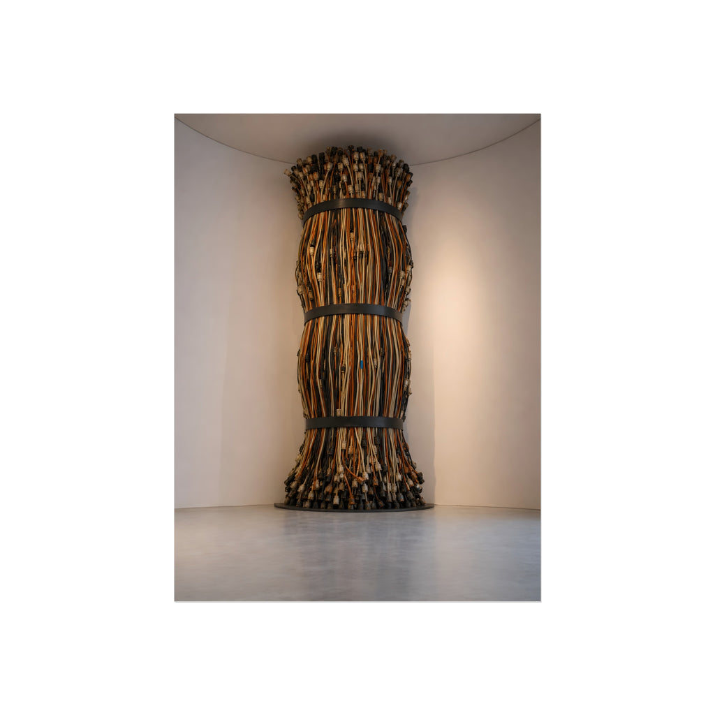 A tall column of bundled cords strapped in three places in a gallery corner. The Bundled Apse by Garabaggio, fine art print, 12″ x 16″.
