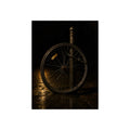A bare bicycle wheel locked to a post on wet pavement. The Wheel Without a Bicycle by Garabaggio, fine art print, 12″ x 16″.