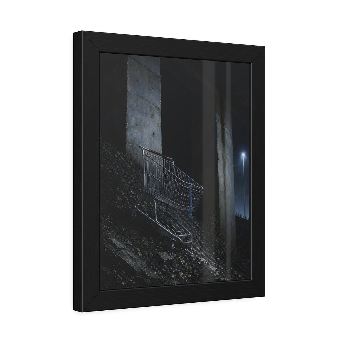 A shopping cart on a rocky slope under an overpass near a streetlamp. The Descent to the Underpass by Garabaggio, framed fine art print hanging in a room.