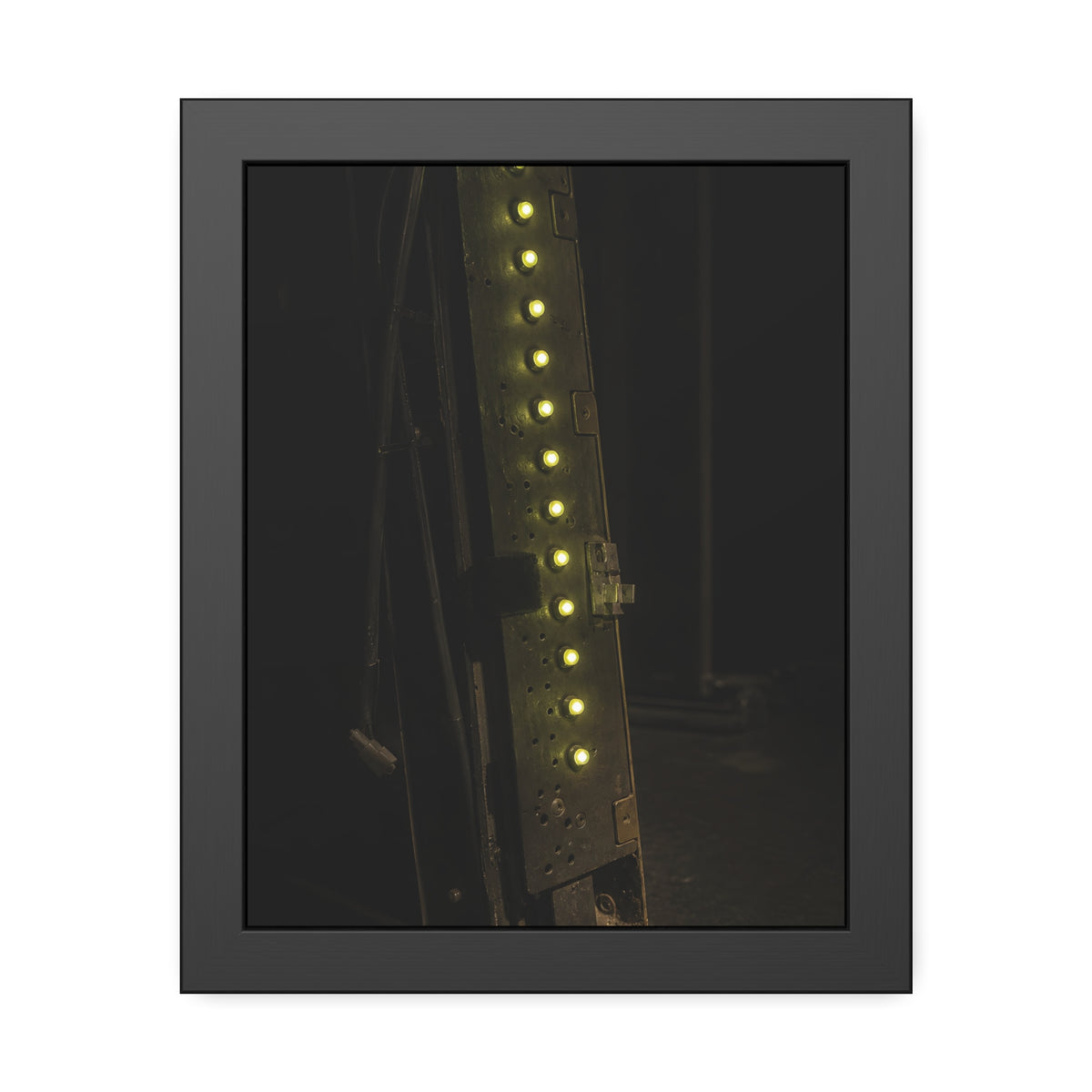 A dark rack panel with a vertical row of glowing green indicator lights. The First Green Choir by Garabaggio, framed fine art print, 11″ x 14″.