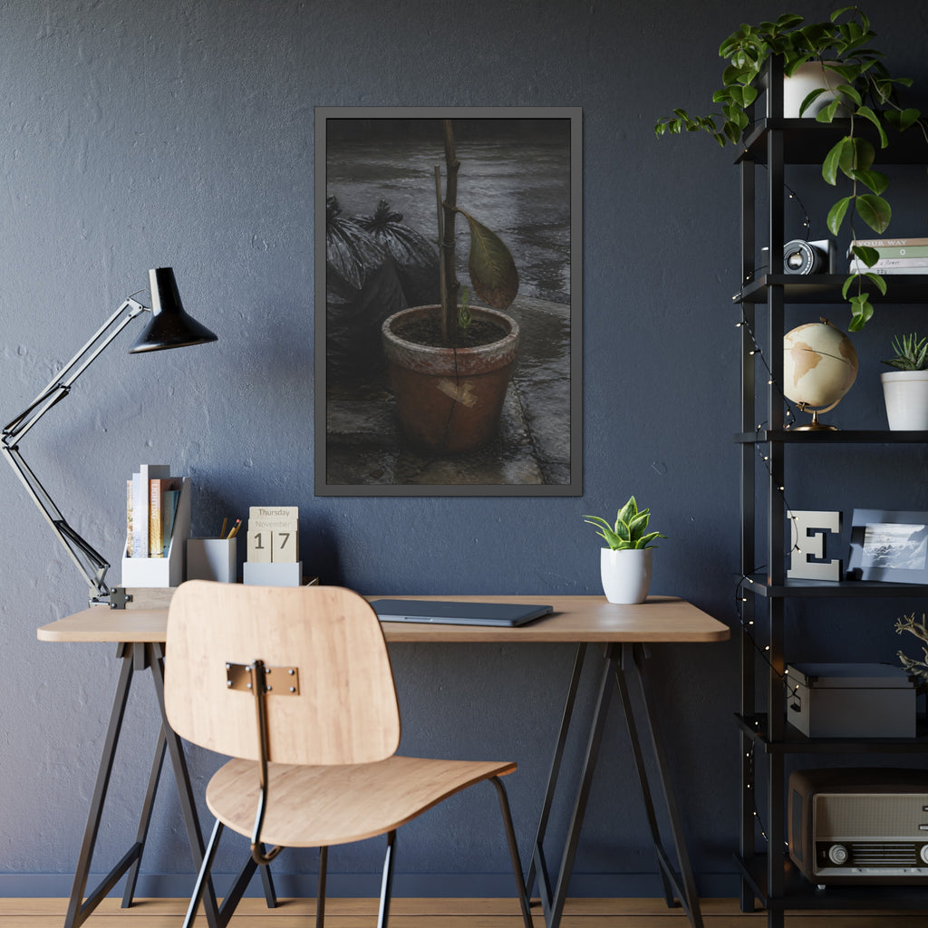 A taped clay pot with one leaf and a green shoot on wet pavement. The Green at the Base by Garabaggio, framed fine art print hanging in a room.