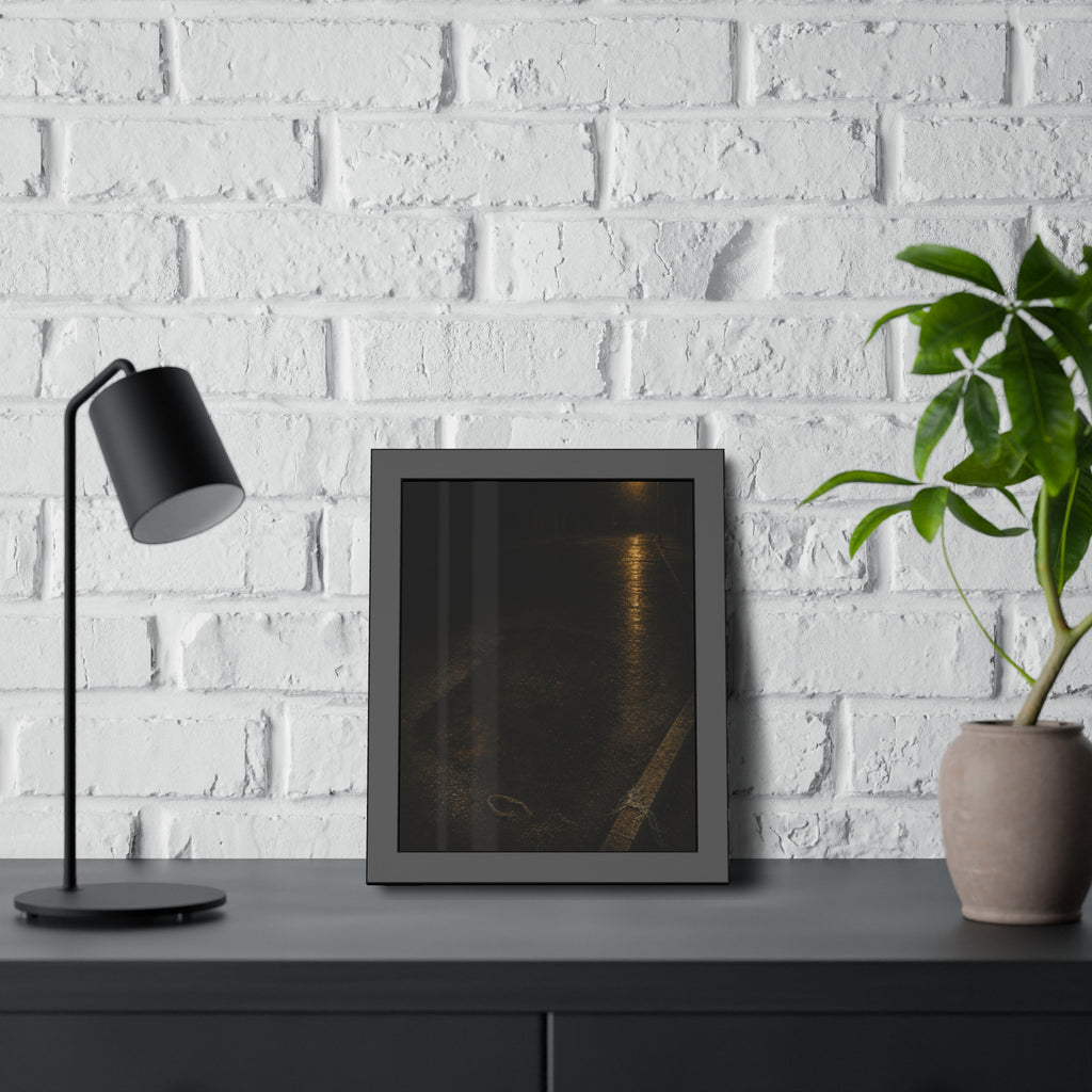 A rectangular stain on wet asphalt where something lay, under a streetlamp. The Stain After Removal by Garabaggio, framed fine art print hanging in a room.