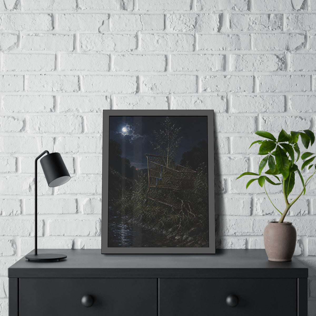 A shopping cart in creekside weeds with a sapling growing up through it. The Cart Grown Through by Garabaggio, framed fine art print hanging in a room.