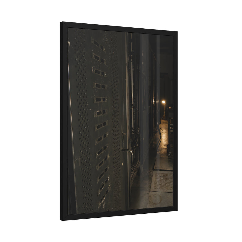 Rows of dark server cabinets with one work lamp glowing far down the aisle. Racks Without Light by Garabaggio, framed fine art print hanging in a room.