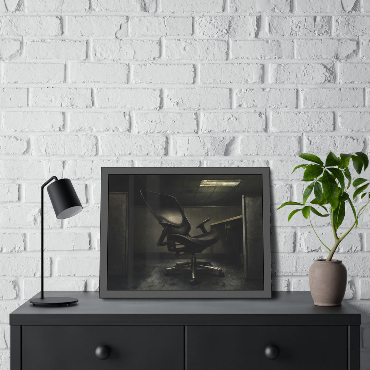 An office chair tilted back in an empty cubicle under one ceiling light. The Ergonomic Chair, Unlocked by Garabaggio, framed fine art print hanging in a room.