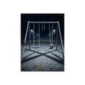 A frost covered swing set on empty asphalt under distant floodlights. The Third Hour: The Coldest Part by Garabaggio, fine art print, 12″ x 16″.