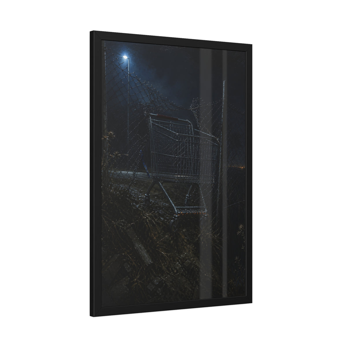 A shopping cart wedged in a chain link fence under a streetlamp. The Abandonment at the Ravine Fence by Garabaggio, framed fine art print hanging in a room.