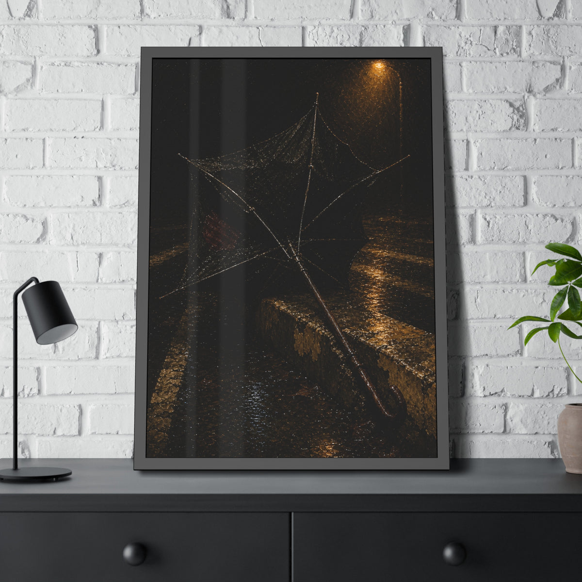 A broken umbrella inside out on a wet curb under a street lamp. The Inversion at the Median by Garabaggio, framed fine art print hanging in a room.