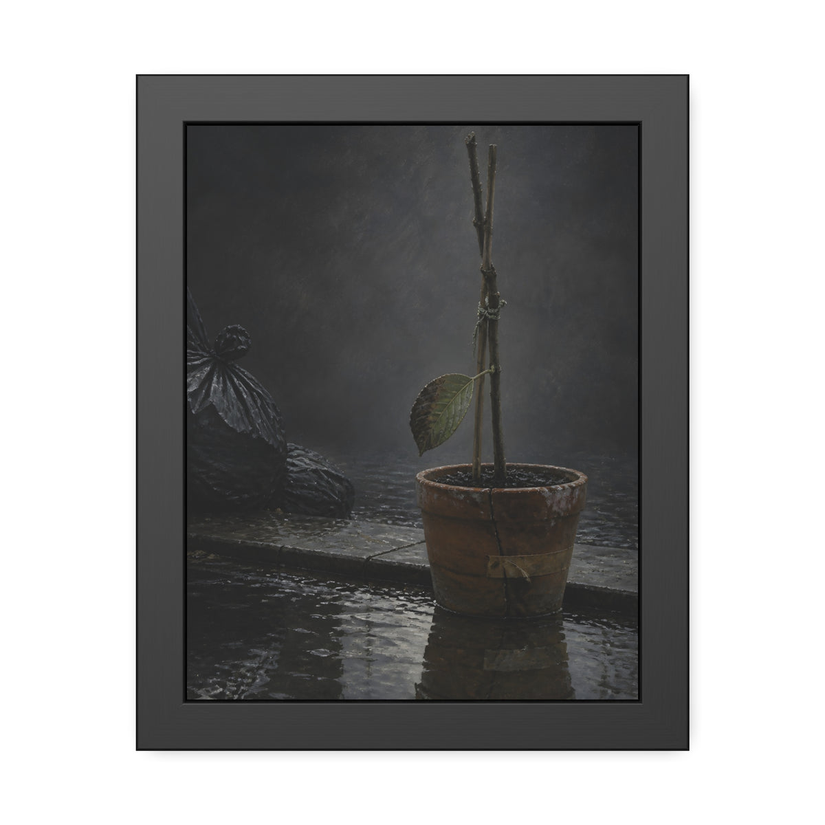 Bare tied stems in a clay pot on flooded pavement, one leaf remaining. The Grey Between by Garabaggio, framed fine art print, 11″ x 14″.