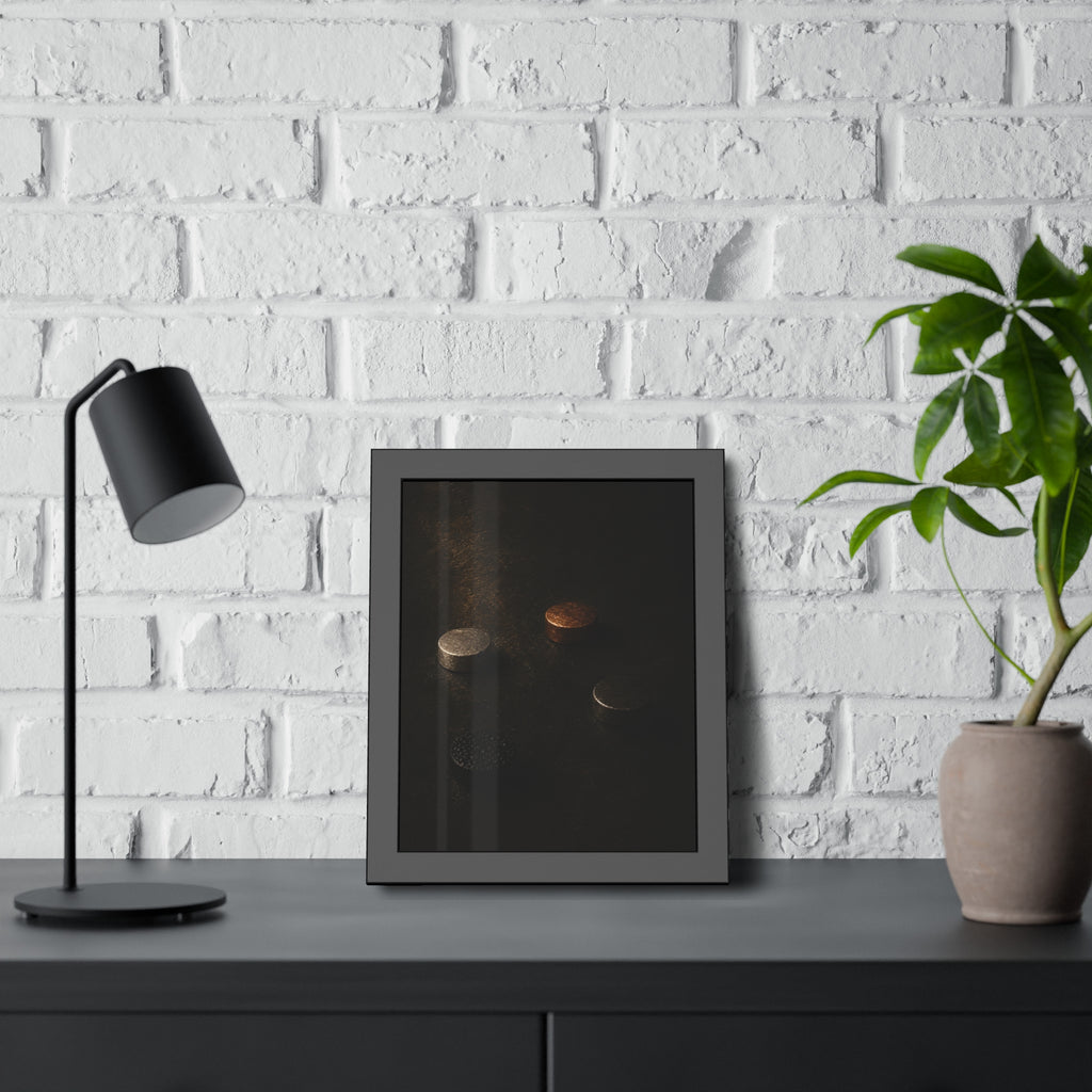 Four small metal discs on a dark scuffed surface in a narrow beam of light. Metals After the Song by Garabaggio, framed fine art print hanging in a room.