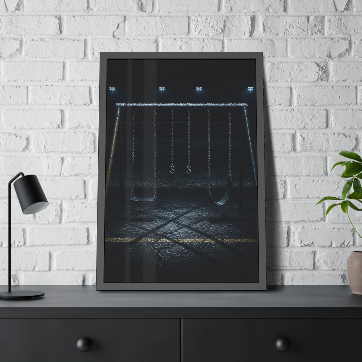 An empty swing set at night, chains still, floodlights far behind it. The Tenth Hour: The Chains Settle by Garabaggio, framed fine art print hanging in a room.