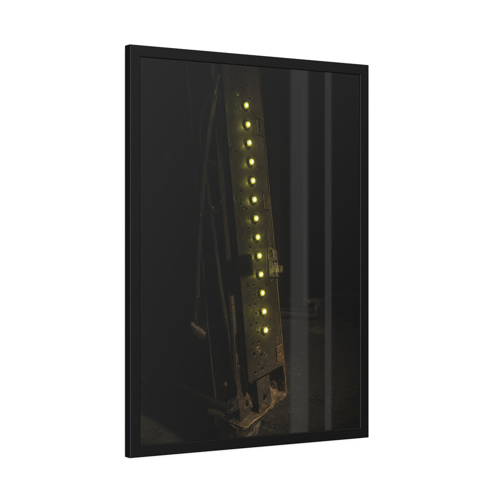 A dark rack panel with a vertical row of glowing green indicator lights. The First Green Choir by Garabaggio, framed fine art print hanging in a room.