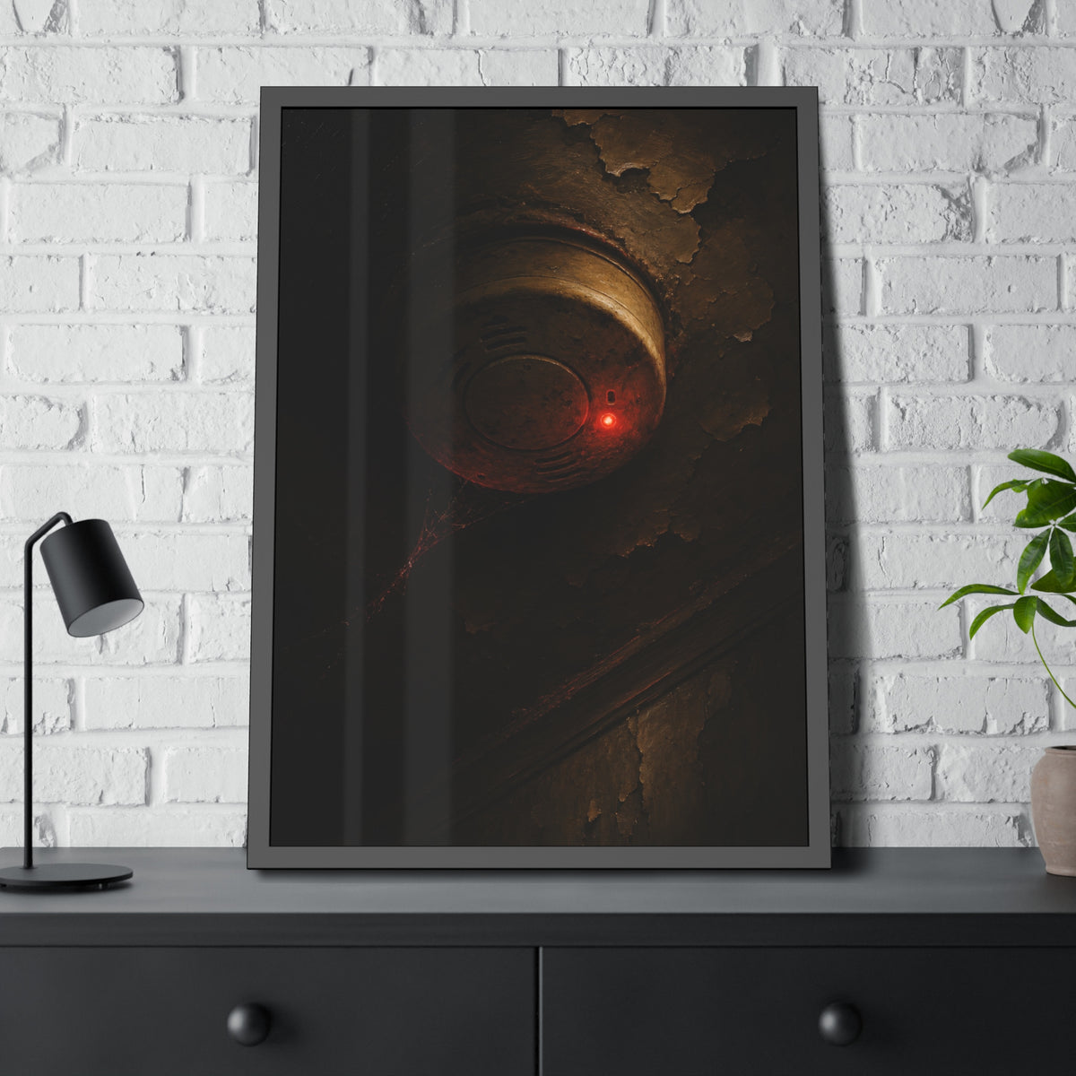 A smoke detector with a red light on a peeling ceiling, cobwebs beneath. The Chirp at Three Forty by Garabaggio, framed fine art print hanging in a room.