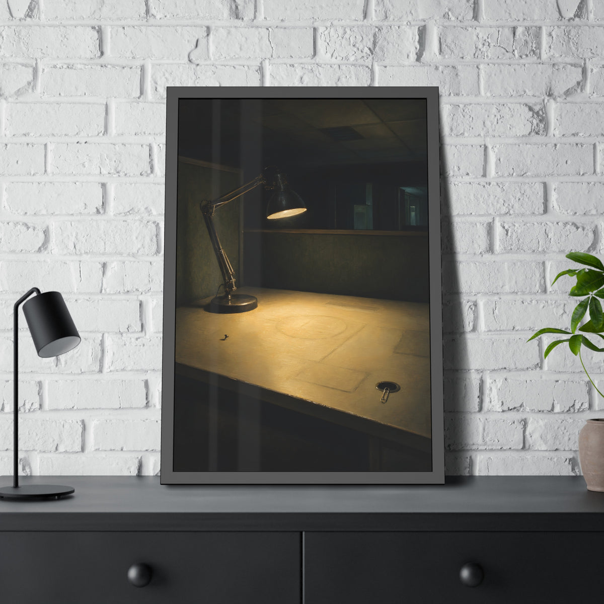 A lit desk lamp on an emptied office desk at night. The Desk Lamp Still Warm by Garabaggio, framed fine art print hanging in a room.