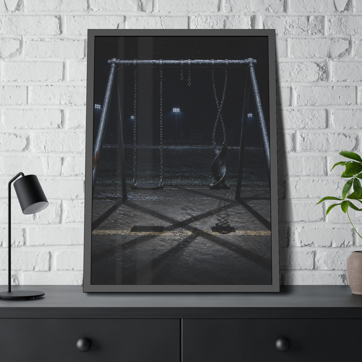 An empty swing set at night with one seat twisted up on its chains. The First Hour: The Twisted Seat by Garabaggio, framed fine art print hanging in a room.