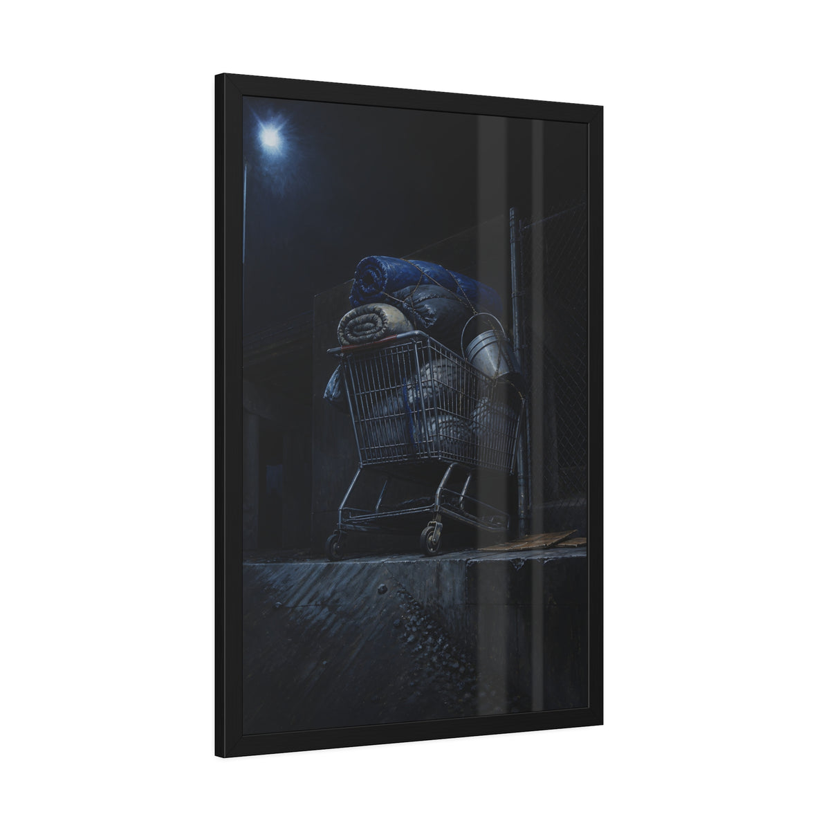 A shopping cart piled with bedding and buckets under a streetlamp. The Loading of Another Life by Garabaggio, framed fine art print hanging in a room.