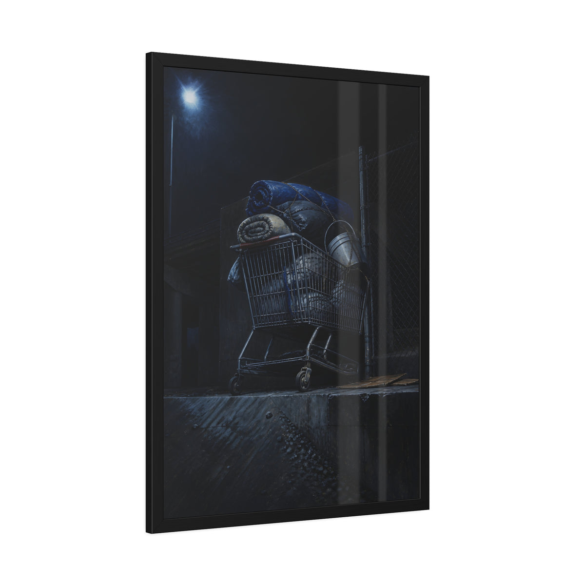 A shopping cart piled with bedding and buckets under a streetlamp. The Loading of Another Life by Garabaggio, framed fine art print hanging in a room.
