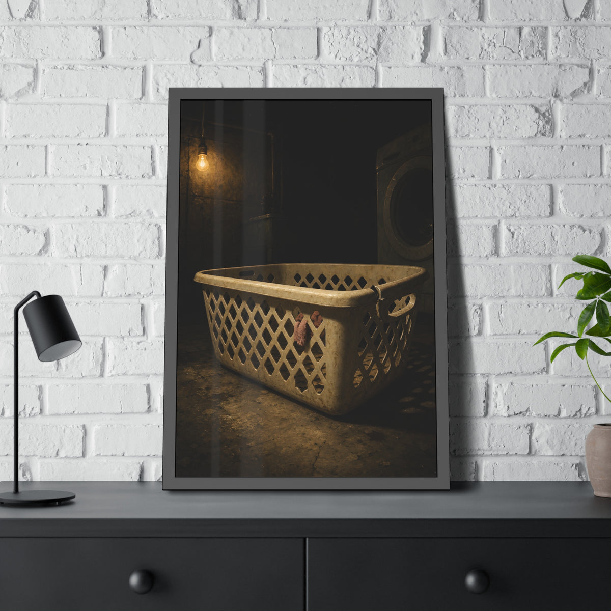 A plastic laundry basket on a basement floor under a bare hanging bulb. The First Split by Garabaggio, framed fine art print hanging in a room.